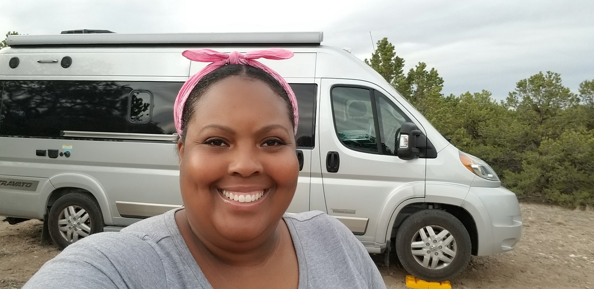 Woman smiling in front of a campervan