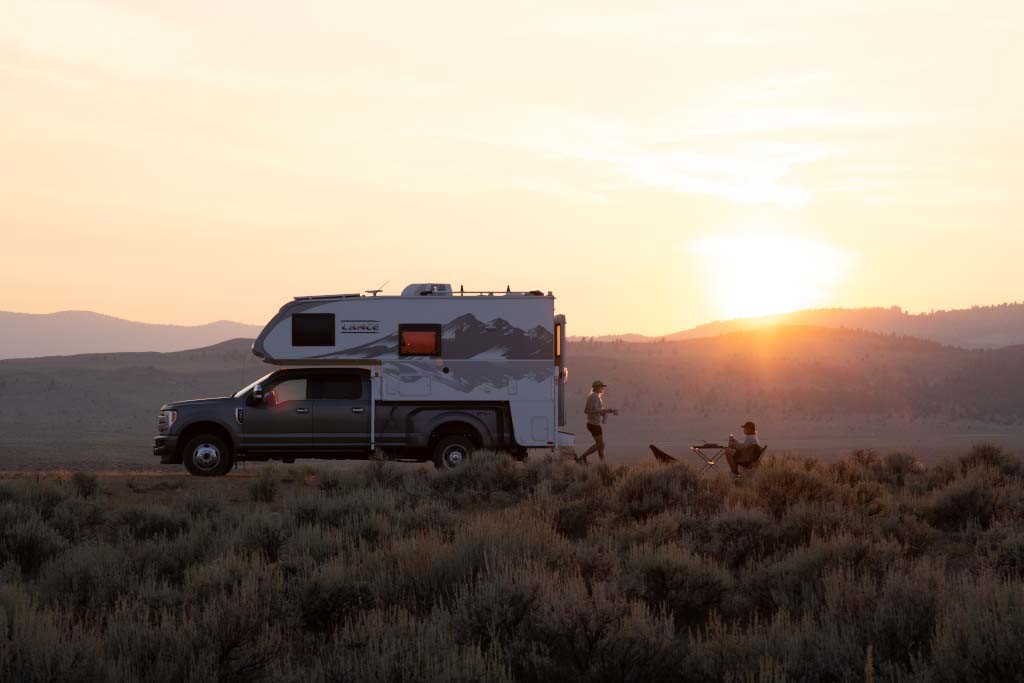 Truck camper with mountains in the background