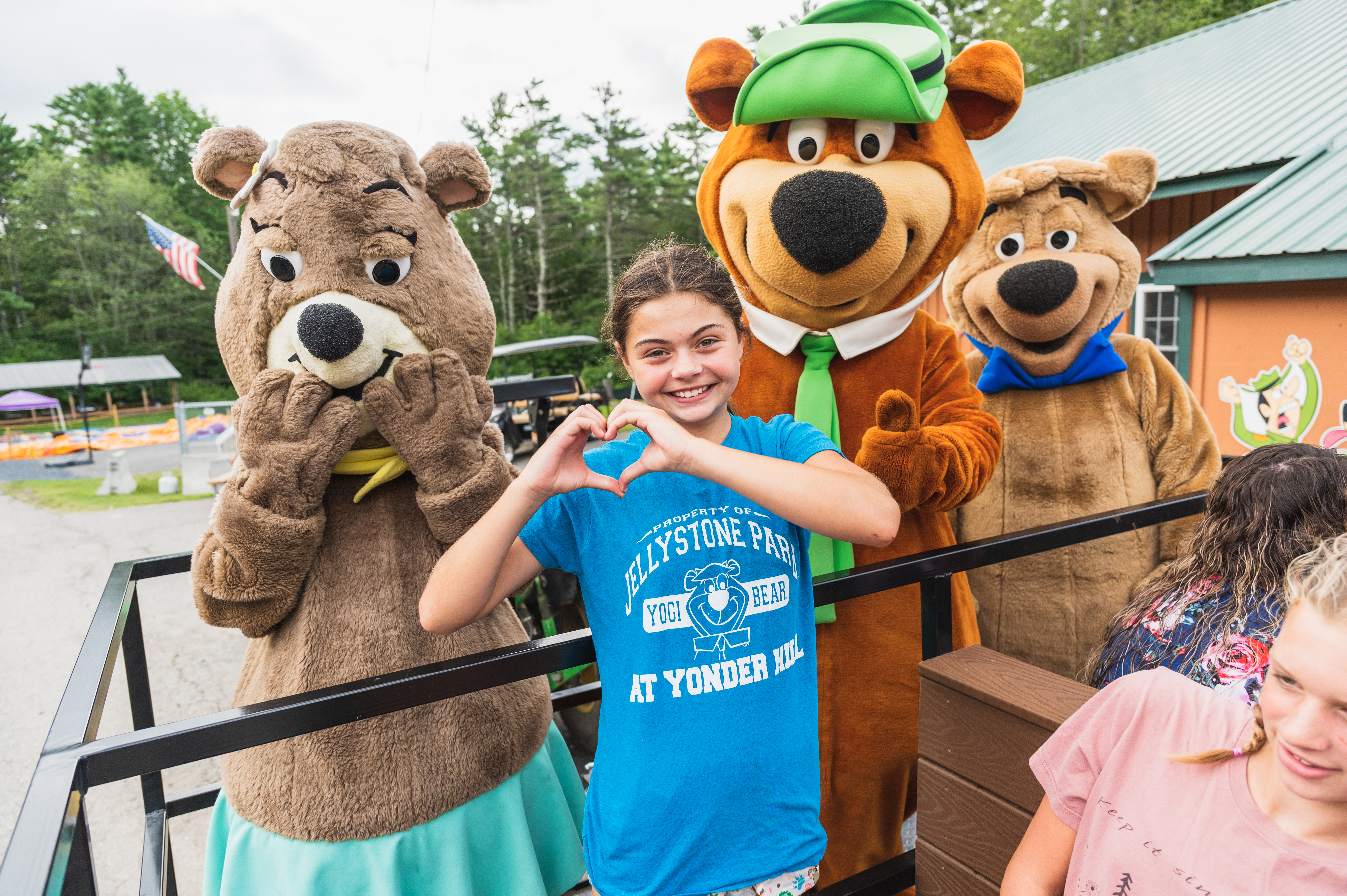 Young girl standing in front of Yogi Bear at Jellystone