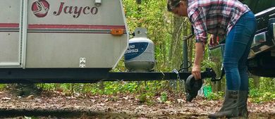 Woman Hitching Travel Trailer to Truck