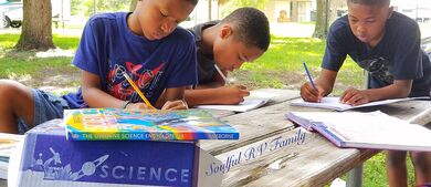 3 boys studying at picnic table