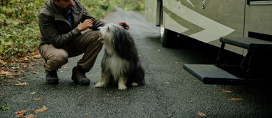 Man with dog in front of RV