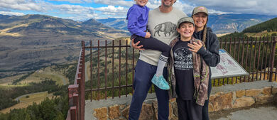 Family poses for a photo in front of mountain view