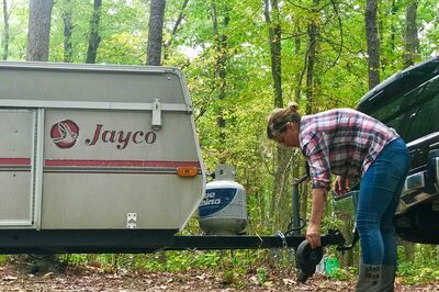 Woman Hitching Travel Trailer to Truck