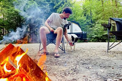 man at fire feeding dog