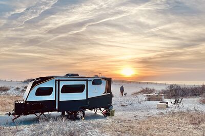 Travel trailer on beach at sunset
