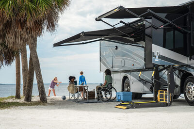 People gathered next to accessible RV on the beach