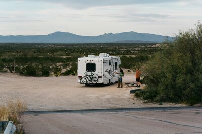 A parked Class C with mountains on the horizon