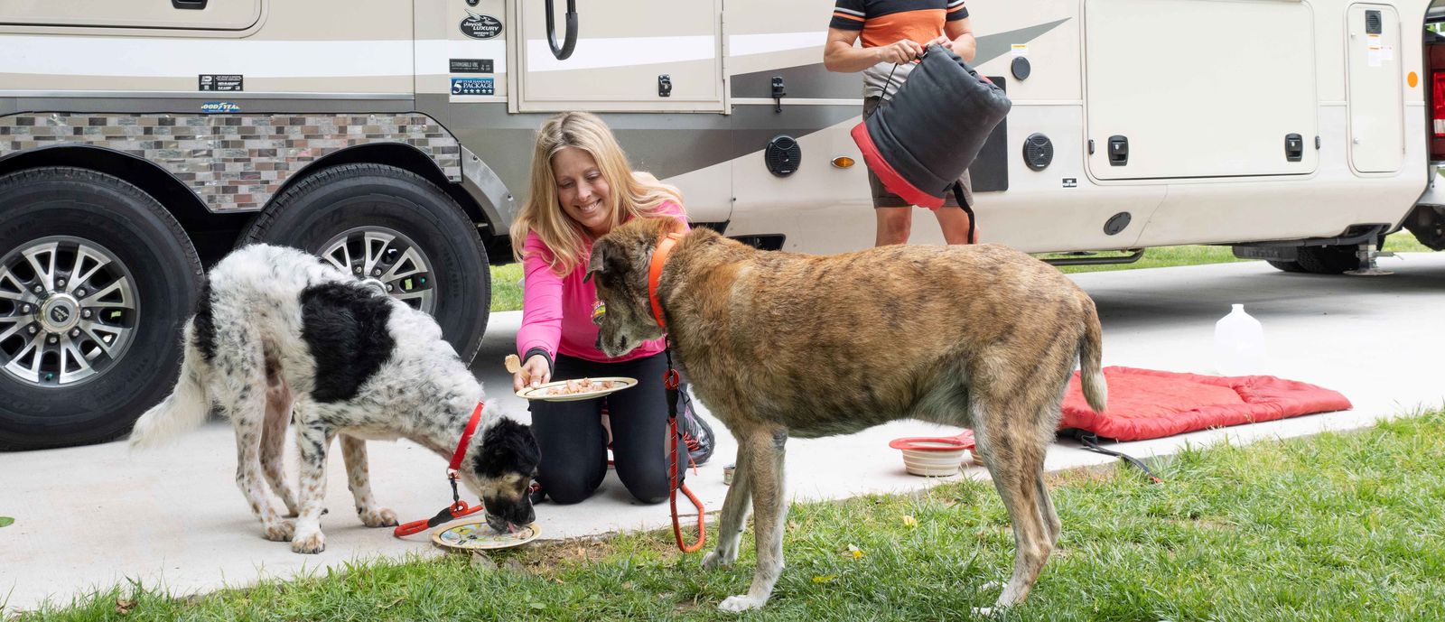 couple with two dogs in front of RV