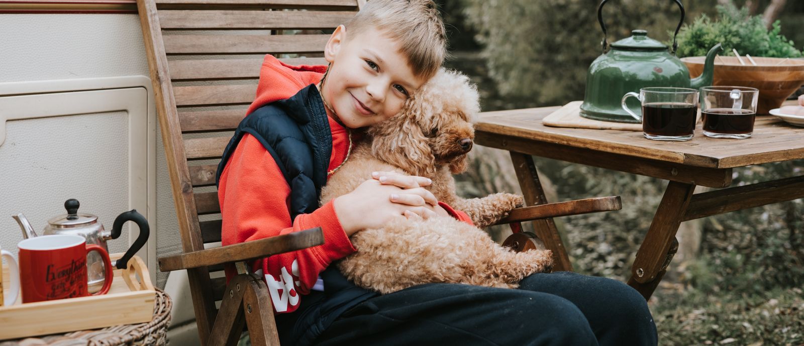 Boy sitting with puppy outside RV
