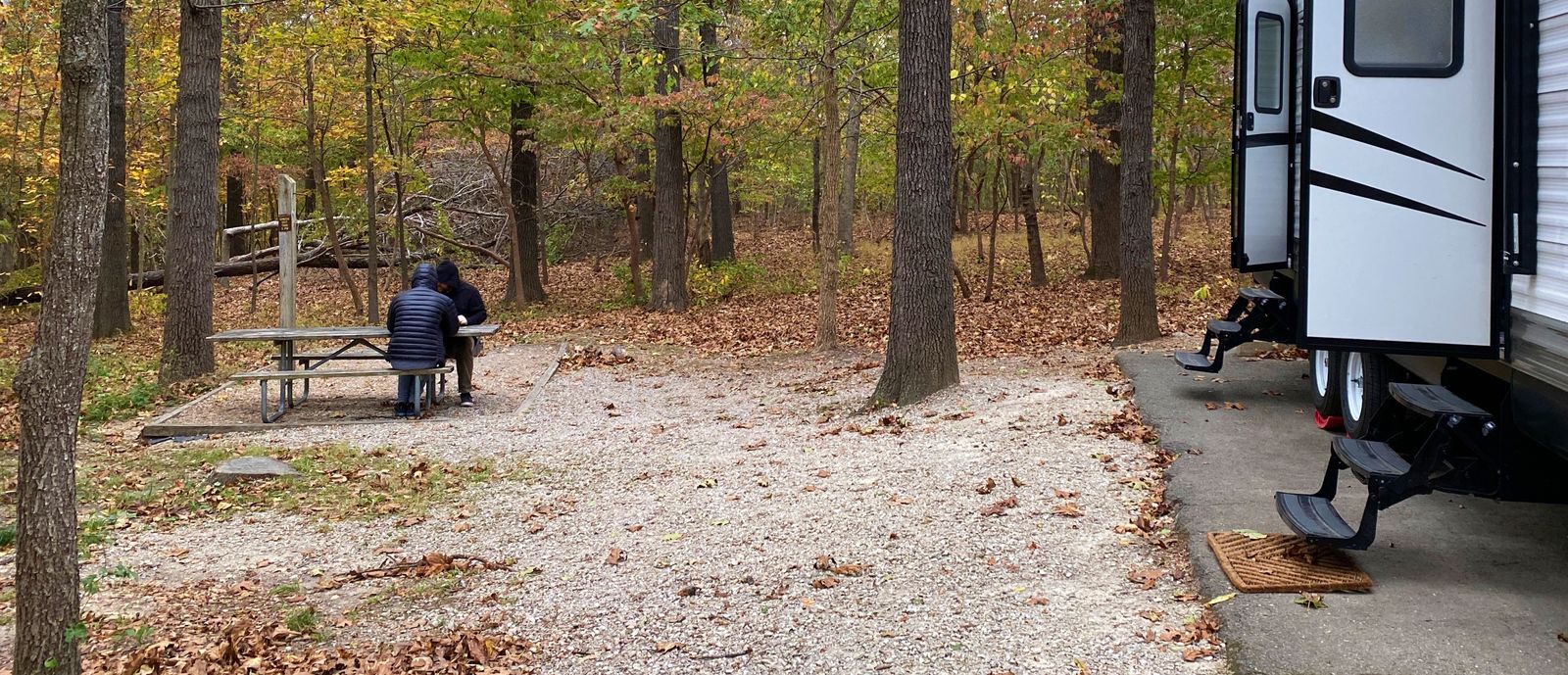 RV sitting in woods in the fall