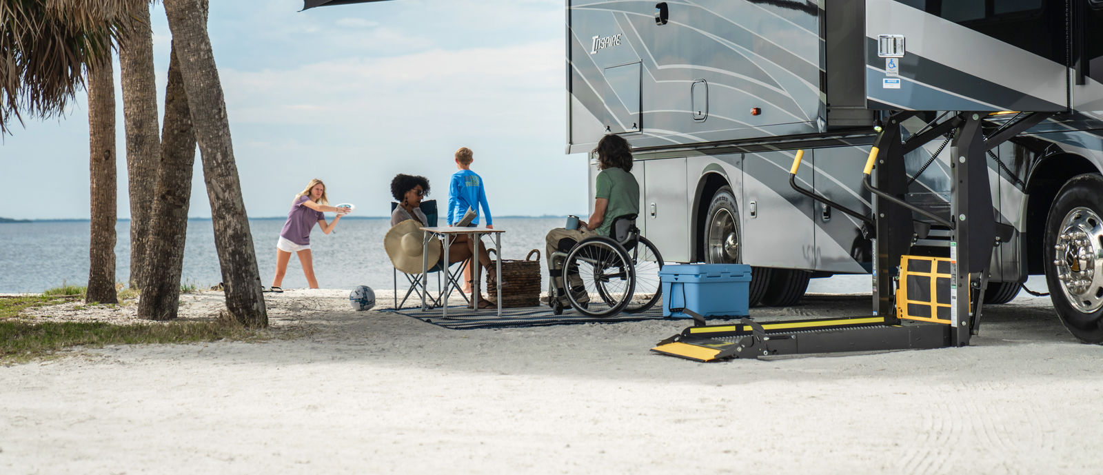 People gathered next to accessible RV on the beach
