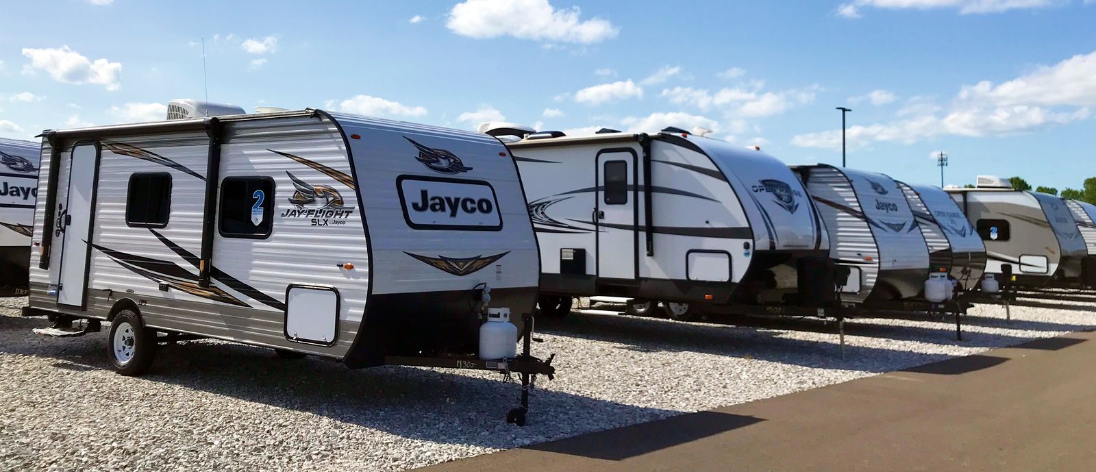 Travel trailers at a dealership on a sunny day