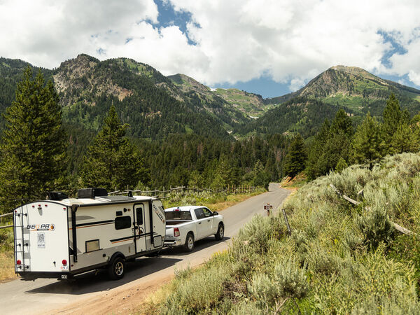 A truck tows an RV through the mountains.