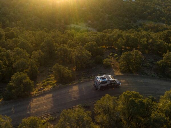 An aerial view of a truck camper driving down a road