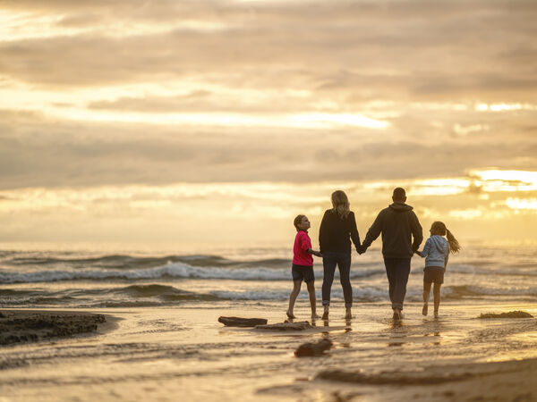 Family walks along the shore together