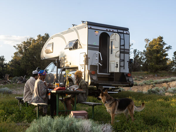 People share a meal together near their RV.