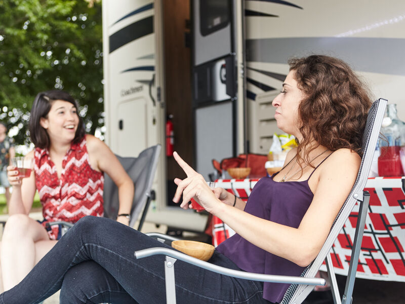 Travelers relax outside their RV.