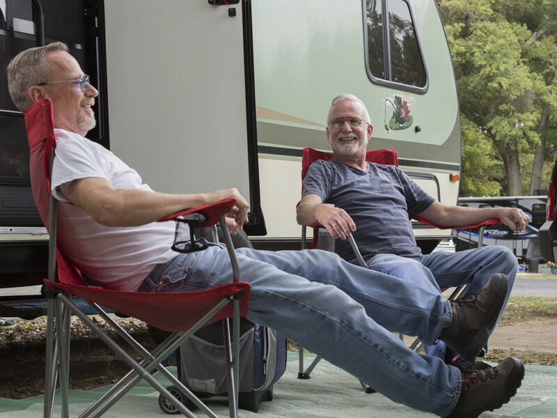 Travelers relax outside of their RV