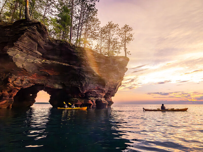 Sun Sets As Family Emerges From Cave While Kayaking At Sea Caves Apostle Islands_Light Leak