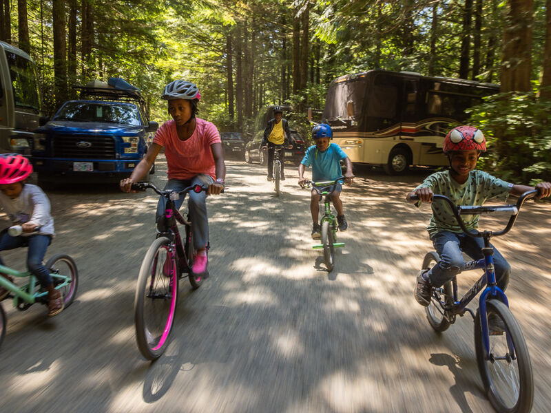 Children riding bikes past RVs